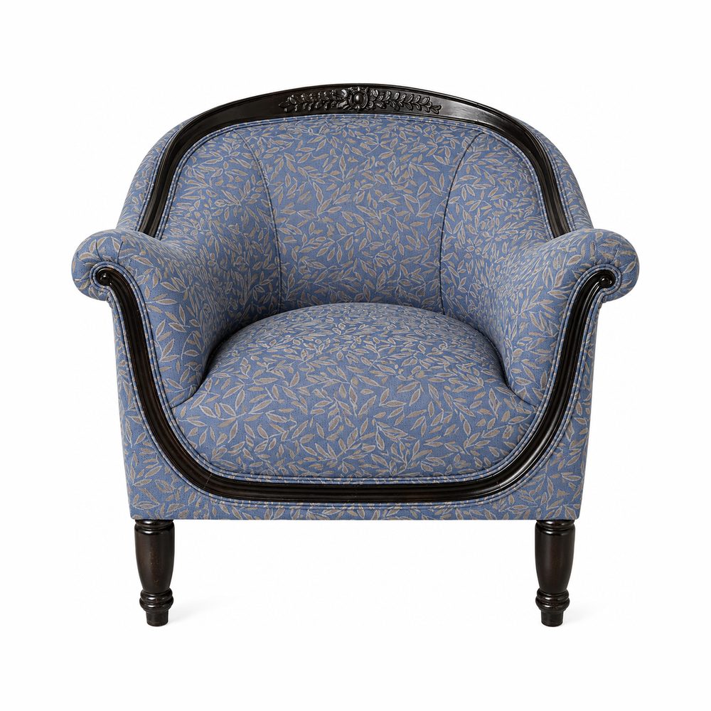 Fauteuil tonneau à bois noirci sculpté, recouvert d’un tissé bleu à feuillage.