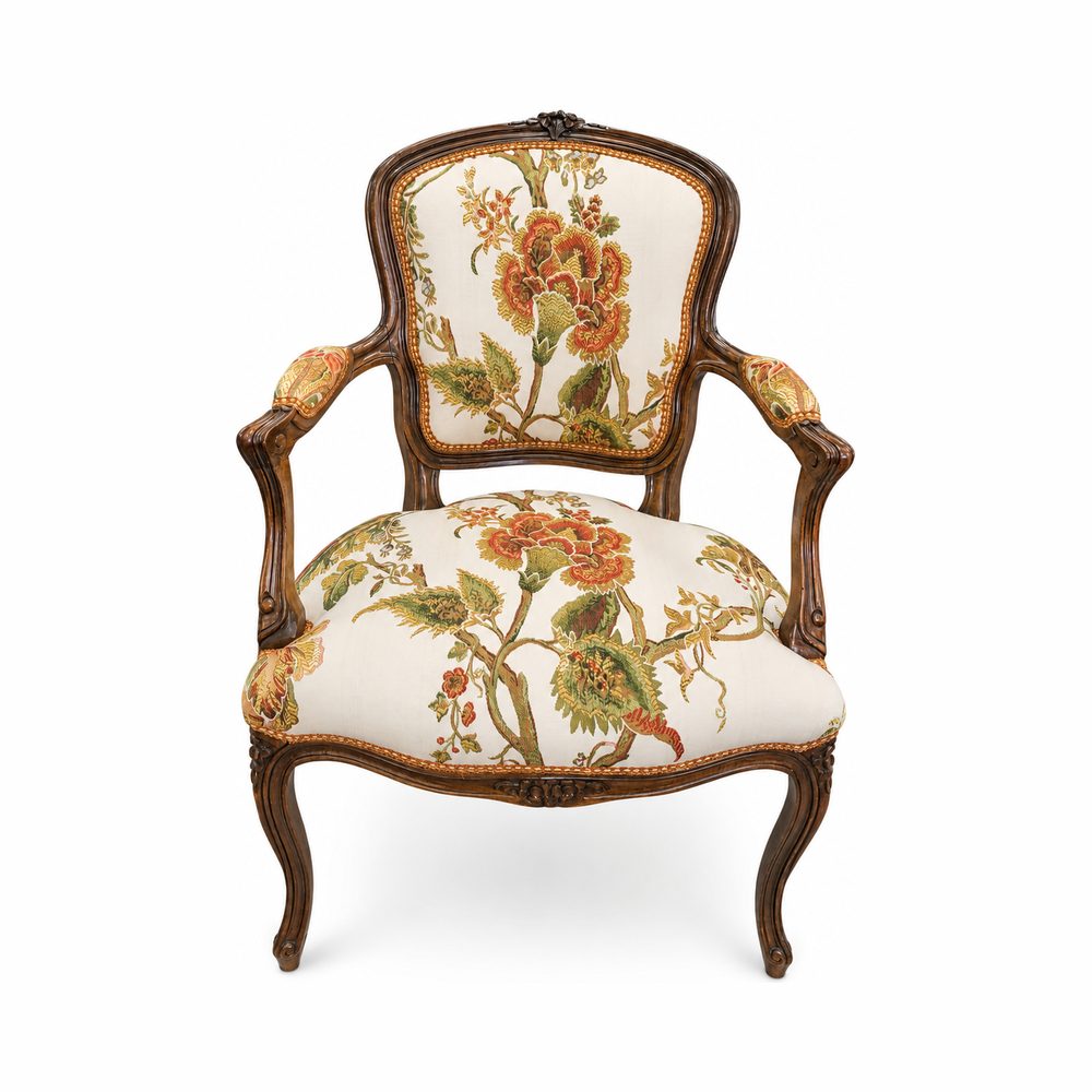 Fauteuil Louis XV recouvert d’un imprimé floral, galon clouté sur bois apparent.