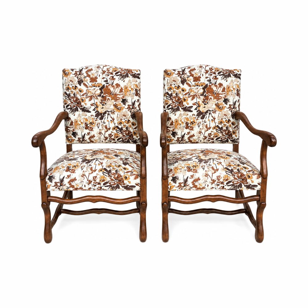 Paire de fauteuils os-de-mouton recouverts d’un imprimé floral, bois clair.