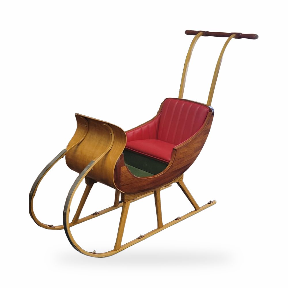 Traîneau ancien en bois cintré, assise refaite en cuir rouge à cannelures.